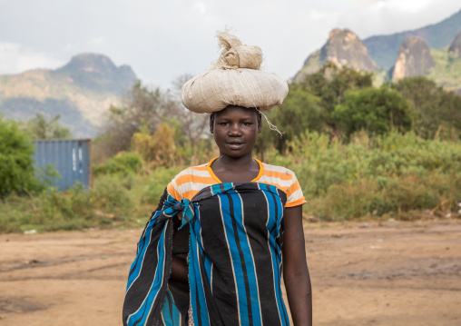 Larim tribe woman carrying heavy bag on her head, Boya Mountains, Imatong, South Sudan