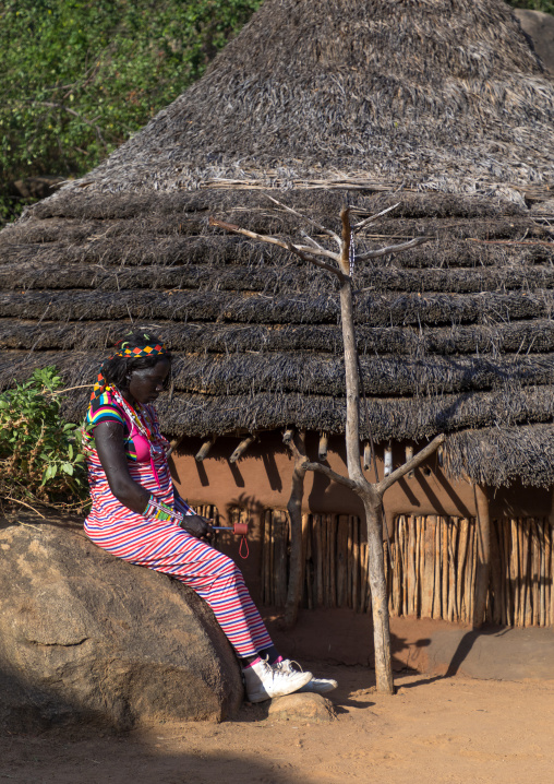 Larim tribe woman sit in front of her house, Boya Mountains, Imatong, South Sudan