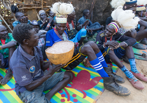 Larim tribe men drinking alcohol in a calabash during a wedding ceremony, Boya Mountains, Imatong, South Sudan
