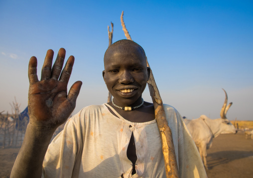 Smiling Mundari tribe boy waving hand to say hello in a cattle camp, Central Equatoria, Terekeka, South Sudan