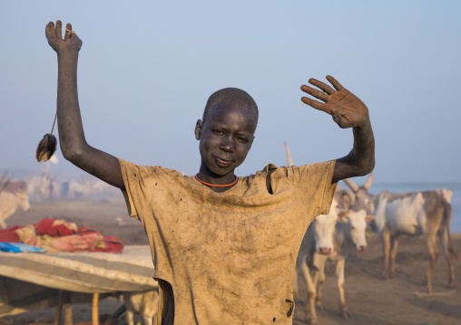 A Mundari tribe boy mimics the position of horns of his favourite cow, Central Equatoria, Terekeka, South Sudan