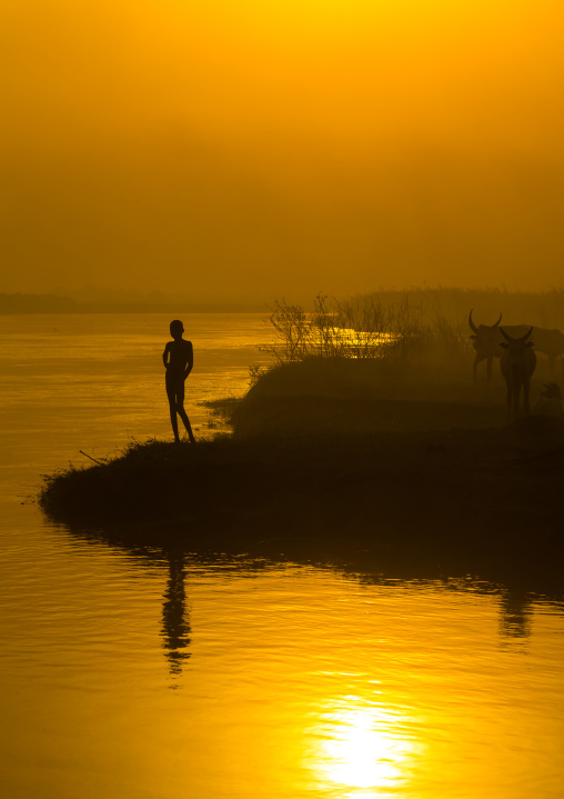 Mundari tribe child on the bank of river Nile at sunset, Central Equatoria, Terekeka, South Sudan