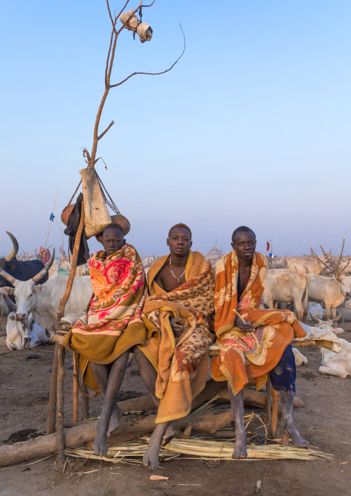 Mundari tribe men sitting on a bed in the early morning in a cattle camp, Central Equatoria, Terekeka, South Sudan