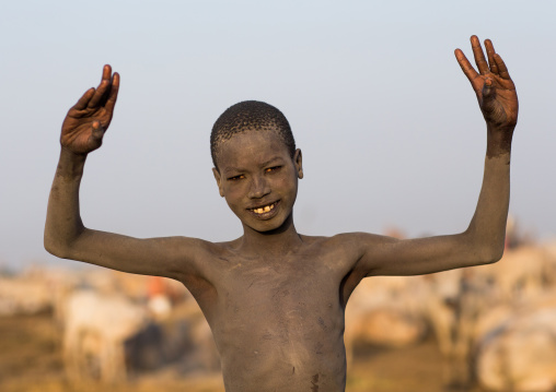 A Mundari tribe boy mimics the position of horns of his favourite cow, Central Equatoria, Terekeka, South Sudan
