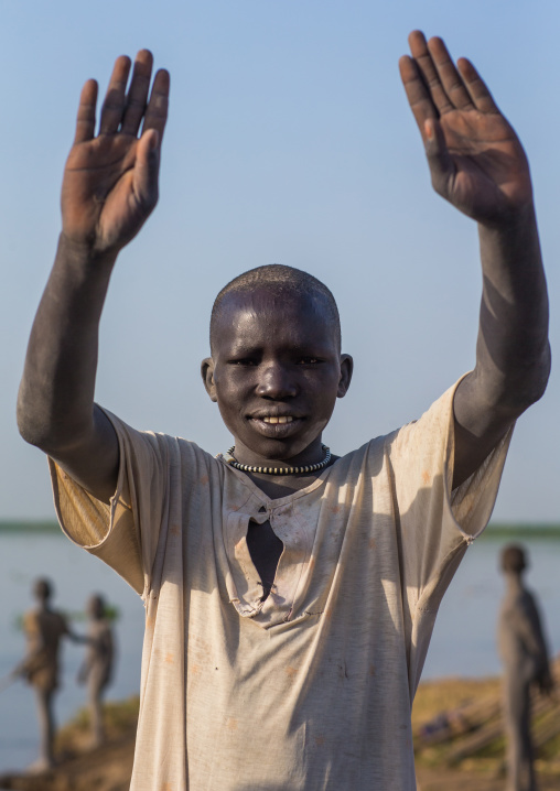 A Mundari tribe boy mimics the position of horns of his favourite cow, Central Equatoria, Terekeka, South Sudan