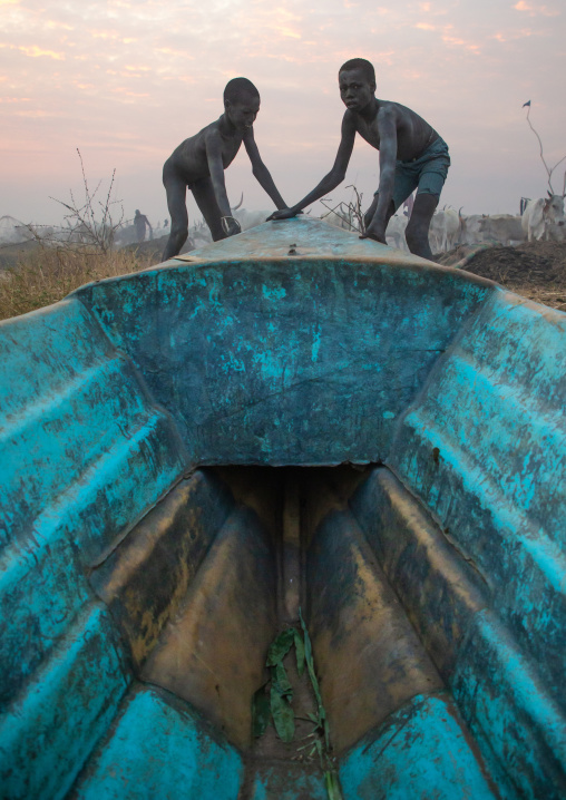 Mundari tribe boys pushing a boat, Central Equatoria, Terekeka, South Sudan