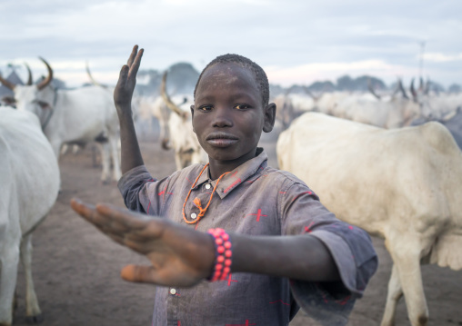 A Mundari tribe boy mimics the position of horns of his favourite cow, Central Equatoria, Terekeka, South Sudan