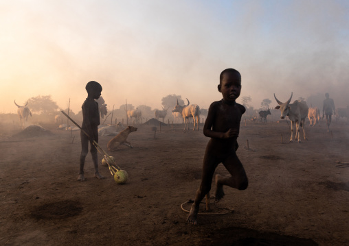 Mundari tribe boys taking care of the bonfires made with dried cow dungs to repel flies and mosquitoes, Central Equatoria, Terekeka, South Sudan