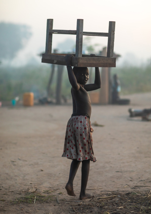 Mundari tribe girl carrying a small table on her head, Central Equatoria, Terekeka, South Sudan