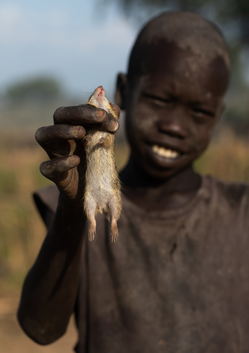 Mundari tribe boy showing a rat he hunted, Central Equatoria, Terekeka, South Sudan