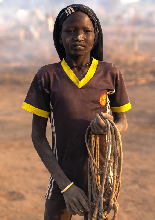 Portrait of a Mundari tribe boy with ropes for the cows wearing a football shirt, Central Equatoria, Terekeka, South Sudan