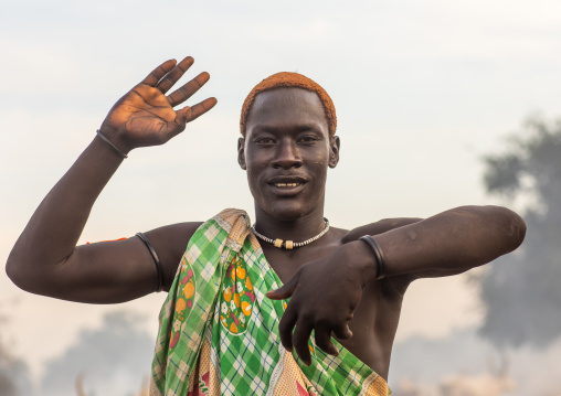 A Mundari tribe man mimics the position of horns of his favourite cow, Central Equatoria, Terekeka, South Sudan