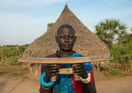 Mundari tribe woman showing a traditional wooden pillow, Central Equatoria, Terekeka, South Sudan