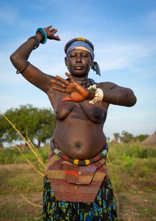 A Mundari tribe woman mimics the position of horns of his favourite cow, Central Equatoria, Terekeka, South Sudan