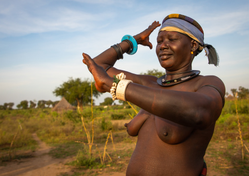 A Mundari tribe woman mimics the position of horns of his favourite cow, Central Equatoria, Terekeka, South Sudan