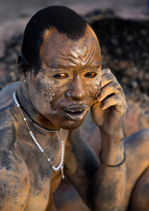 Mundari tribe man covering his body in ash to repel flies and mosquitoes, Central Equatoria, Terekeka, South Sudan