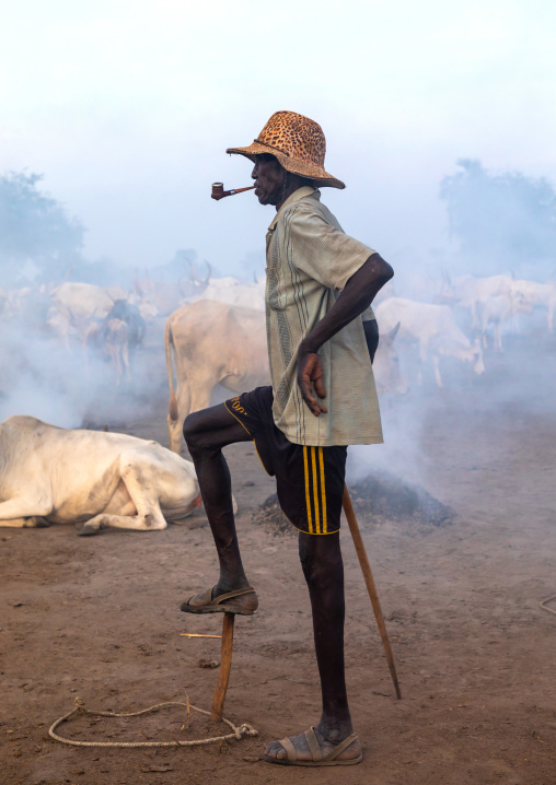 Portrait of a Mundari tribe man smoking a pipe while monitoring his cows, Central Equatoria, Terekeka, South Sudan