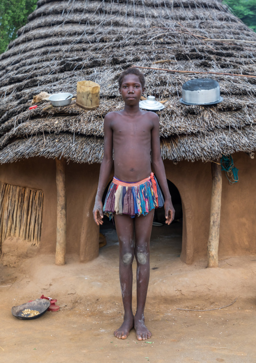 Larim tribe teenage girl in front of her traditional house, Boya Mountains, Imatong, South Sudan