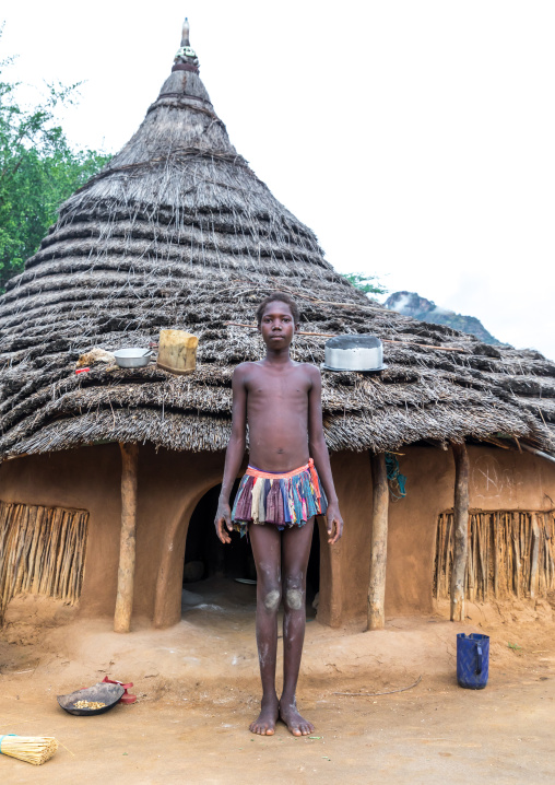 Larim tribe teenage girl in front of her traditional house, Boya Mountains, Imatong, South Sudan