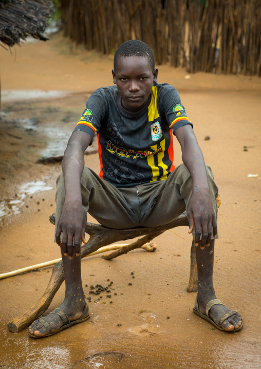 Larim tribe boy sit on a wooden seat, Boya Mountains, Imatong, South Sudan