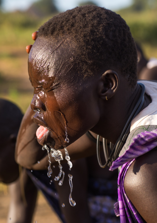 Mundari tribe woman putting water on her face, Central Equatoria, Terekeka, South Sudan