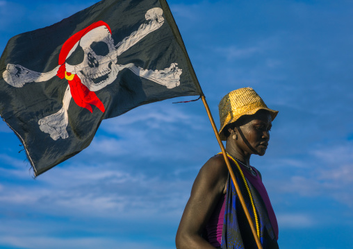 Mundari tribe woman with a pirate flag while celebrating a wedding, Central Equatoria, Terekeka, South Sudan