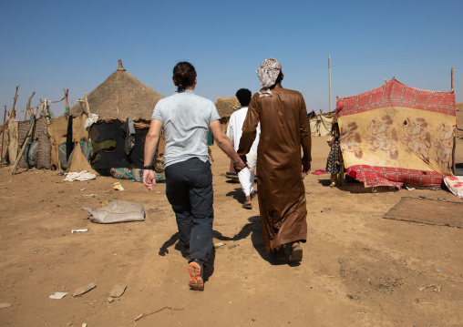 Rashaida man hand in hand with a tourist in a village, Kassala State, Kassala, Sudan