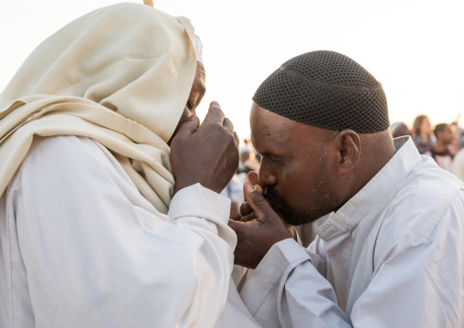Men kissing hands during the friday sufi celebration at sheikh Hamad el Nil tomb, Khartoum State, Omdurman, Sudan