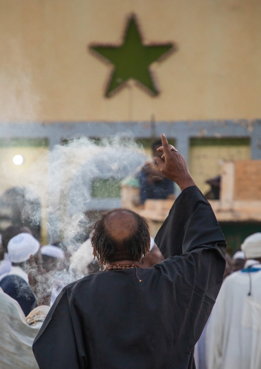 Man with insence burning during the friday sufi celebration at sheikh Hamad el Nil tomb, Khartoum State, Omdurman, Sudan