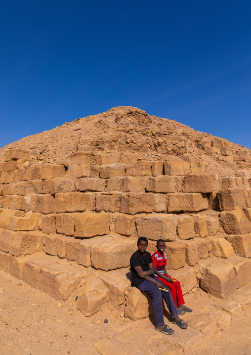 Sudanese children sit on a pyramid in the royal cemetery, Northern State, El-Kurru, Sudan