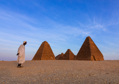 Old sudanese man in front of the meroitic pyramids of jebel Barkal, Northern State, Karima, Sudan