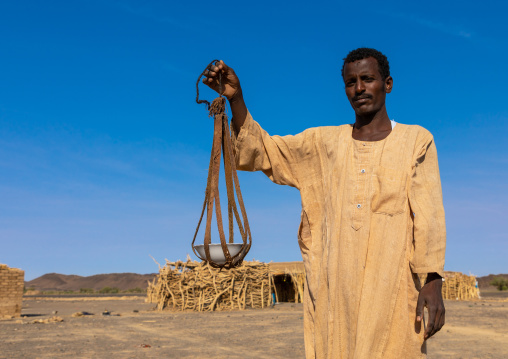 Bedouin arab man with a leather tool for kitchen, Northern State, Bayuda desert, Sudan