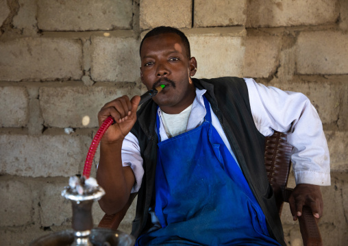 Beja man smoking water pipe, Red Sea State, Suakin, Sudan