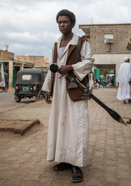 Beja tribe warrior with his sword in the street, Red Sea State, Port Sudan, Sudan