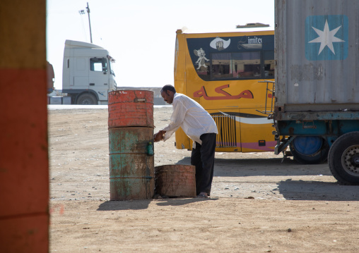 Sudanese man washing his hands in a basin on the road, Red Sea State, Port Sudan, Sudan