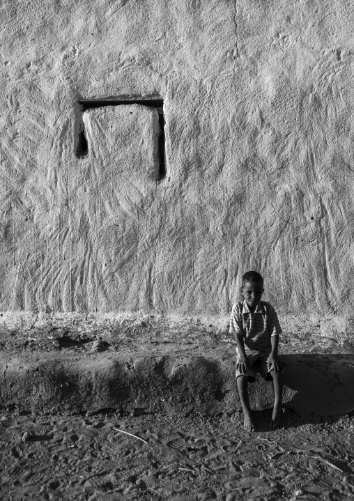 Sudan, Nubia, Tumbus, kid sitting in front of a traditional house