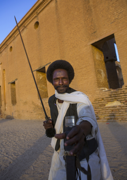 Sudan, Kassala State, Kassala, beja tribe man dancing in front of the khatmiyah mosque at the base of the taka mountains