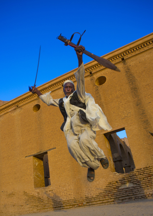 Sudan, Kassala State, Kassala, beja tribe man dancing in front of the khatmiyah mosque at the base of the taka mountains
