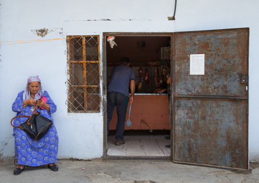 Tadik woman sit in front of the entrance of a butchery, Gorno-Badakhshan autonomous region, Khorog, Tajikistan