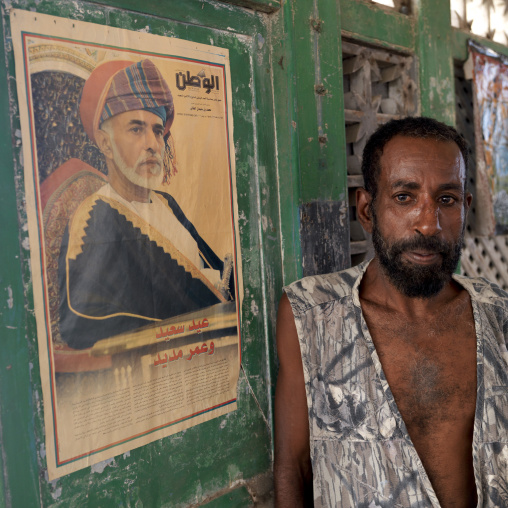 Witchdoctor in front of qaboos sultan portrait from oman, Stone town zanzibar, Tanzania