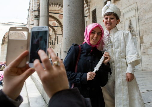 Young turkish boy in the ceremonial circumcision outfit posing with his mother outside the the Blue mosque, Sultanahmet, istanbul, Turkey