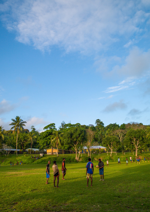Teenagers playing football in a field, Shefa Province, Efate island, Vanuatu