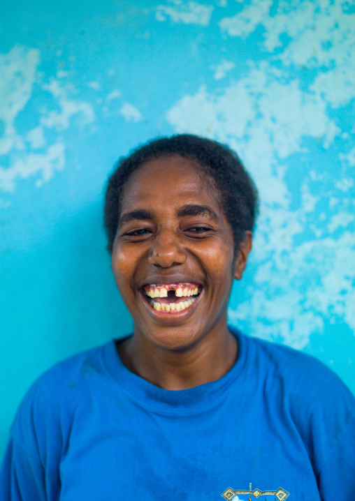 Ni-Vanuatu woman laughing in front of a blue wall, Malampa Province, Malekula Island, Vanuatu