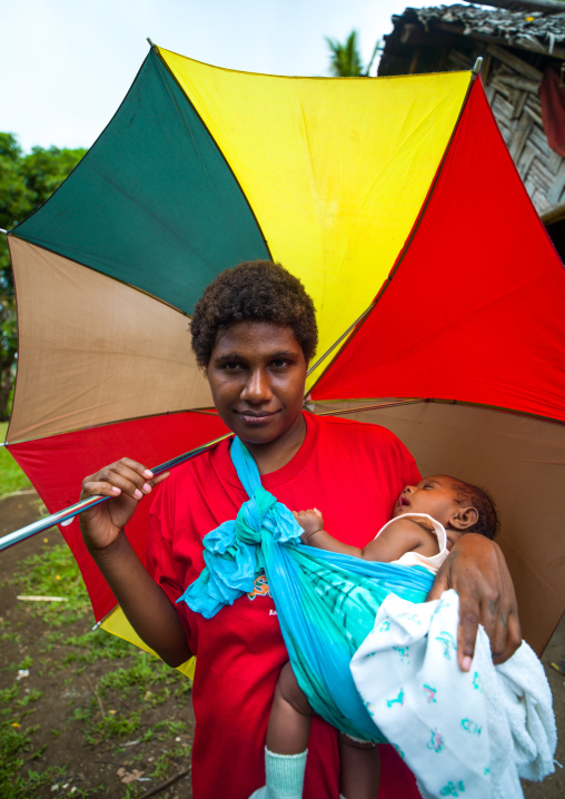 Woman with an umbrella carrying her sleeping baby, Malampa Province, Malekula Island, Vanuatu