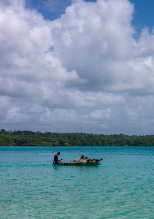 Young boys of the Ni-Vanuatu people paddling in their dugout, Sanma Province, Espiritu Santo, Vanuatu