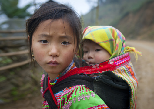 Flower hmong girl carrying her baby sister on her back, Sapa, Vietnam