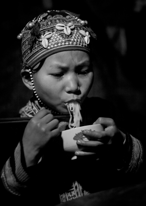 Red dzao girl eating noodles, Sapa, Vietnam