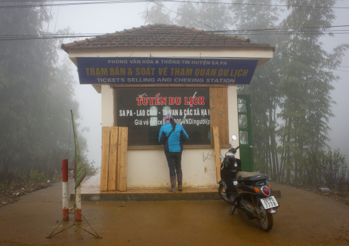 Woman paying the entrance fee of the national park at tha ticket office, Sapa, Vietnam