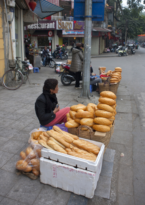 Woman selling bread in the street, Hanoi, Vietnam