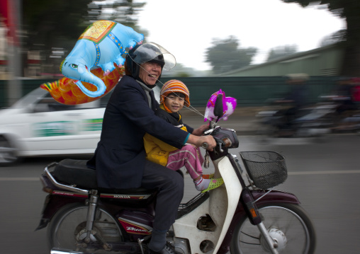 Man and girl on a moped in hanoi, Vietnam